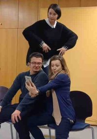 Theaterprobe: Zwei Personen schießen ein Selfie, eine dritte schaut von hinten zu.